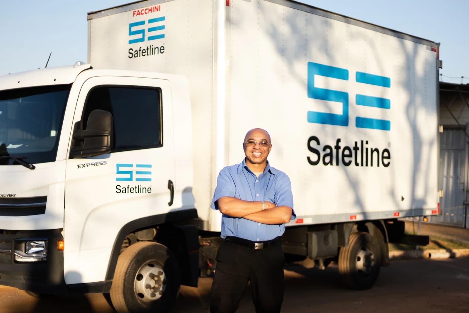 Colaborador Safetline na frente do caminhão de entregas